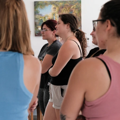 Grupa žena stoji u prostoriji, okrenute prema naprijed s prekriženim rukama