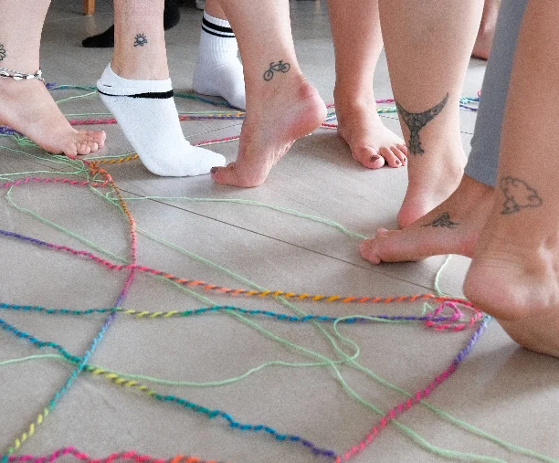 Stopala sudionica u grupnoj aktivnosti s konopima na podu