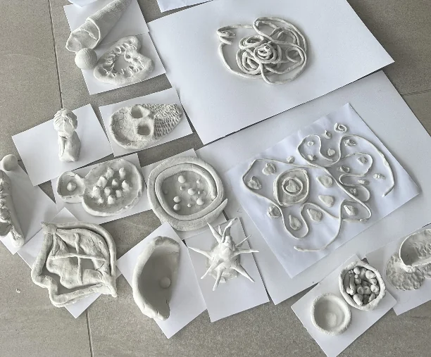 Razne bijele keramičke kreacije izložene na bijelim papirima