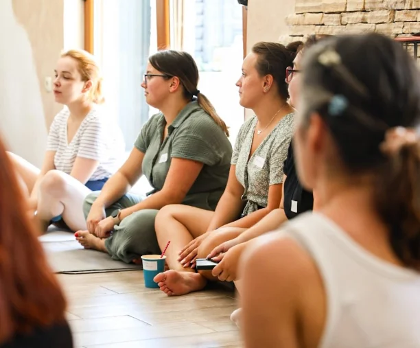 Grupa žena sjedi na podu s prekriženim nogama