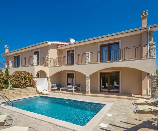 Vila na kat s prostranim bazenom, ležaljkama i terasom na sunčanom danu