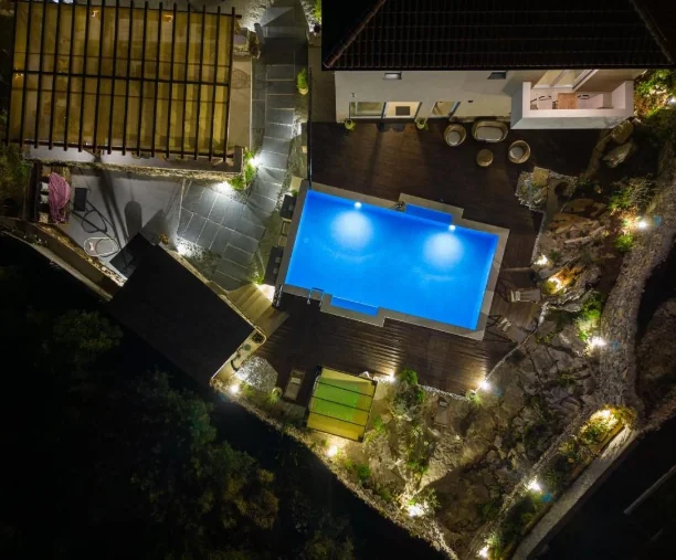 Noćna ptičja perspektiva osvijetljenog bazena i okućnice