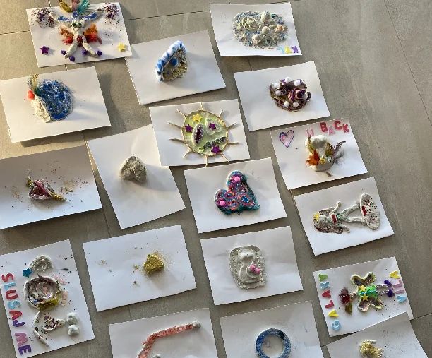 Raznobojni kreativni radovi raspoređeni na podu