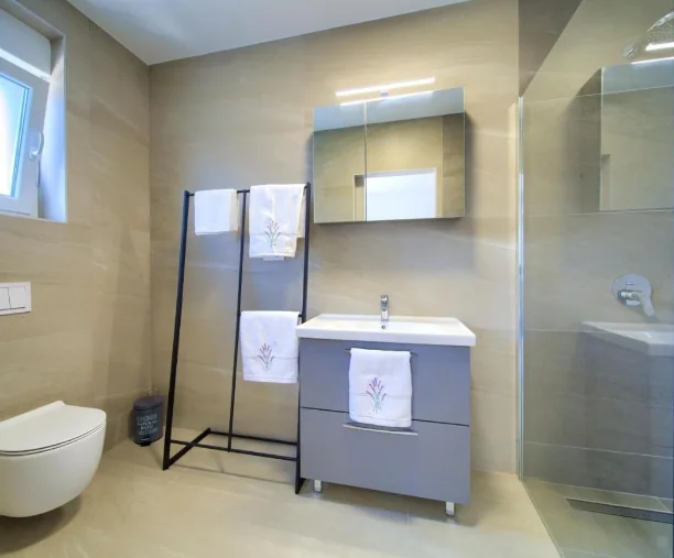 Moderna kupaonica s tuš kabinom, umivaonikom i ručnicima