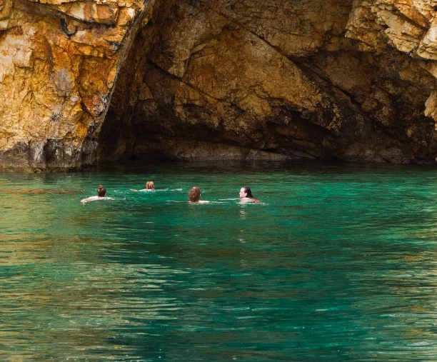 Plivanje u smaragdno zelenoj vodi ispred morske pećine na Krku.