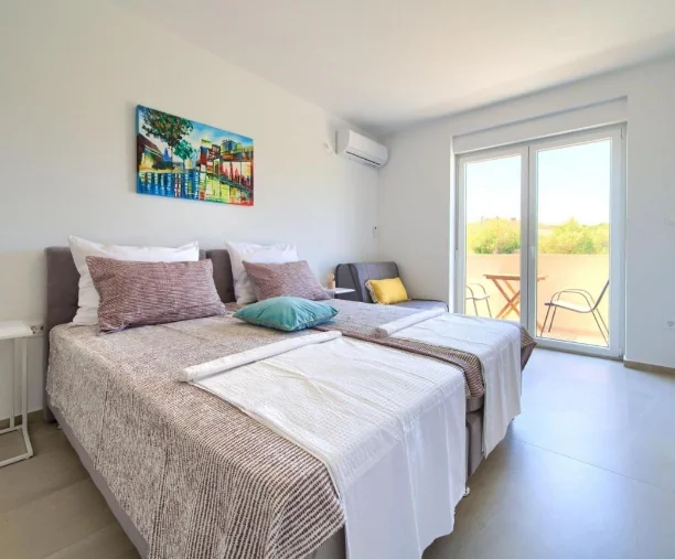 Prostrana spavaća soba s dva spojena kreveta i balkonom