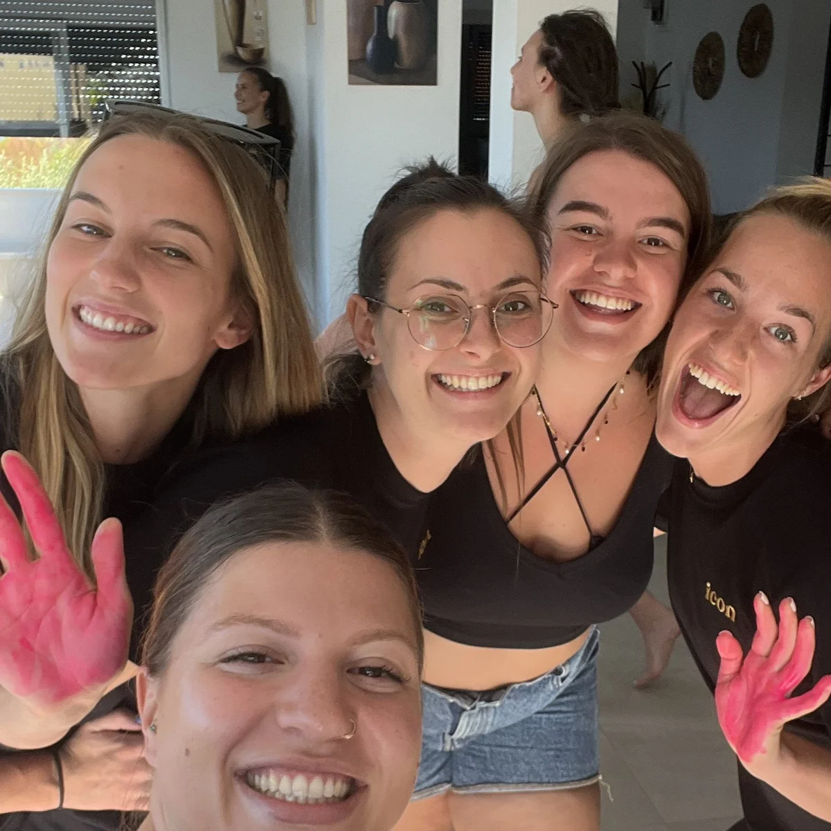 Grupe nasmijanih žena na ženskom retreatu u svijetloj prostoriji.